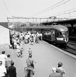 824748 Afbeelding van drukte met treinreizigers bij het in- en uitstappen bij een electrisch treinstel mat. 1946 van de ...